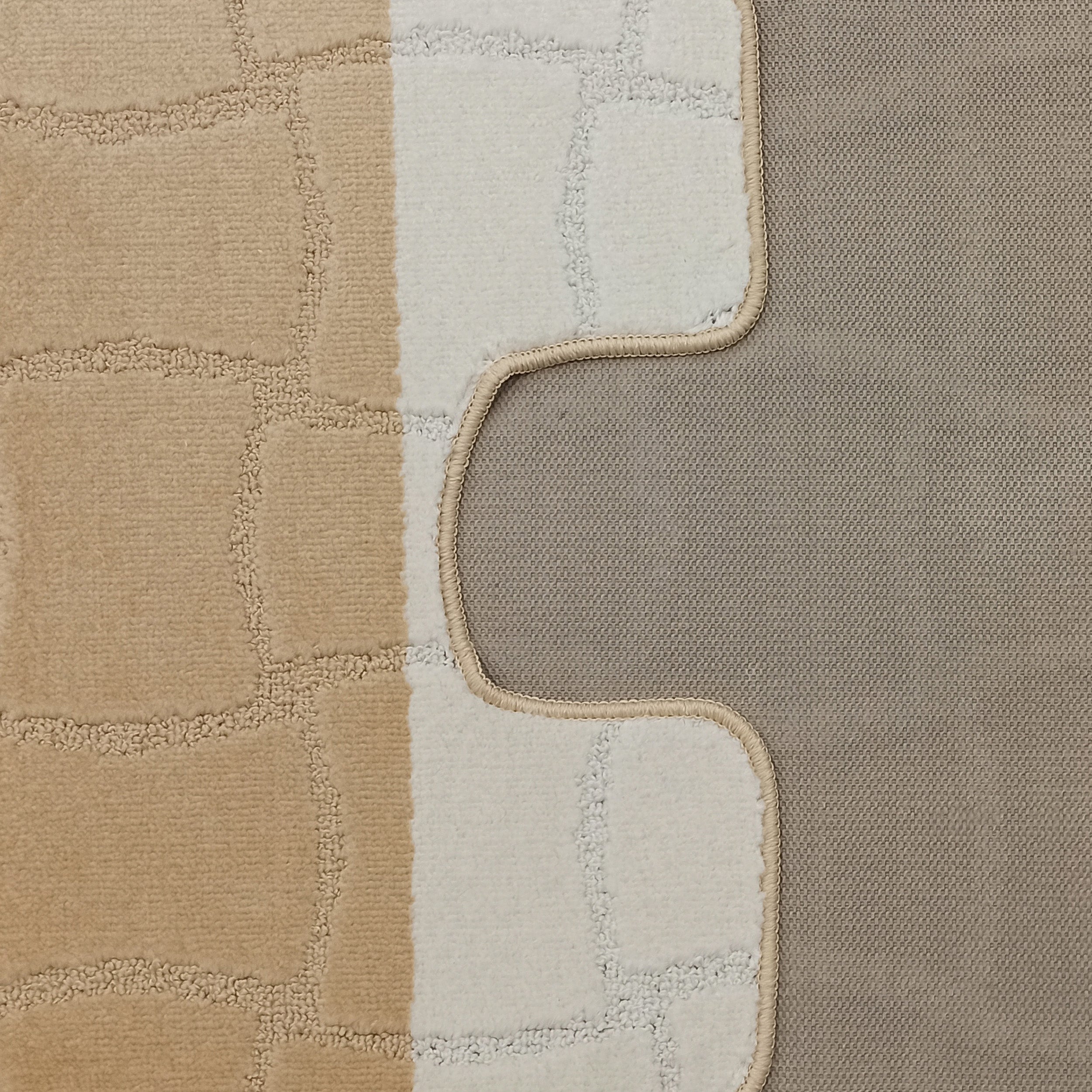 Tapis bicolore beige et crème au motif de pavés irréguliers en relief, révélant sa surface veloutée et son dos tissé