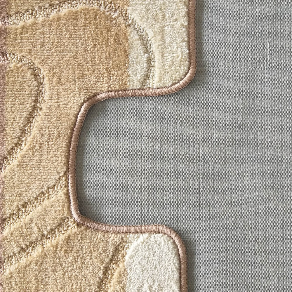 Gros plan sur un tapis texturé aux motifs abstraits beiges, crème et marron, avec un contour ondulé rose sur un sol gris clair