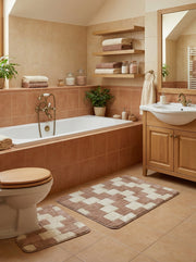 Deux tapis moelleux à carreaux marron-beige et crème, dont un en U devant les toilettes, dans une salle de bain lumineuse