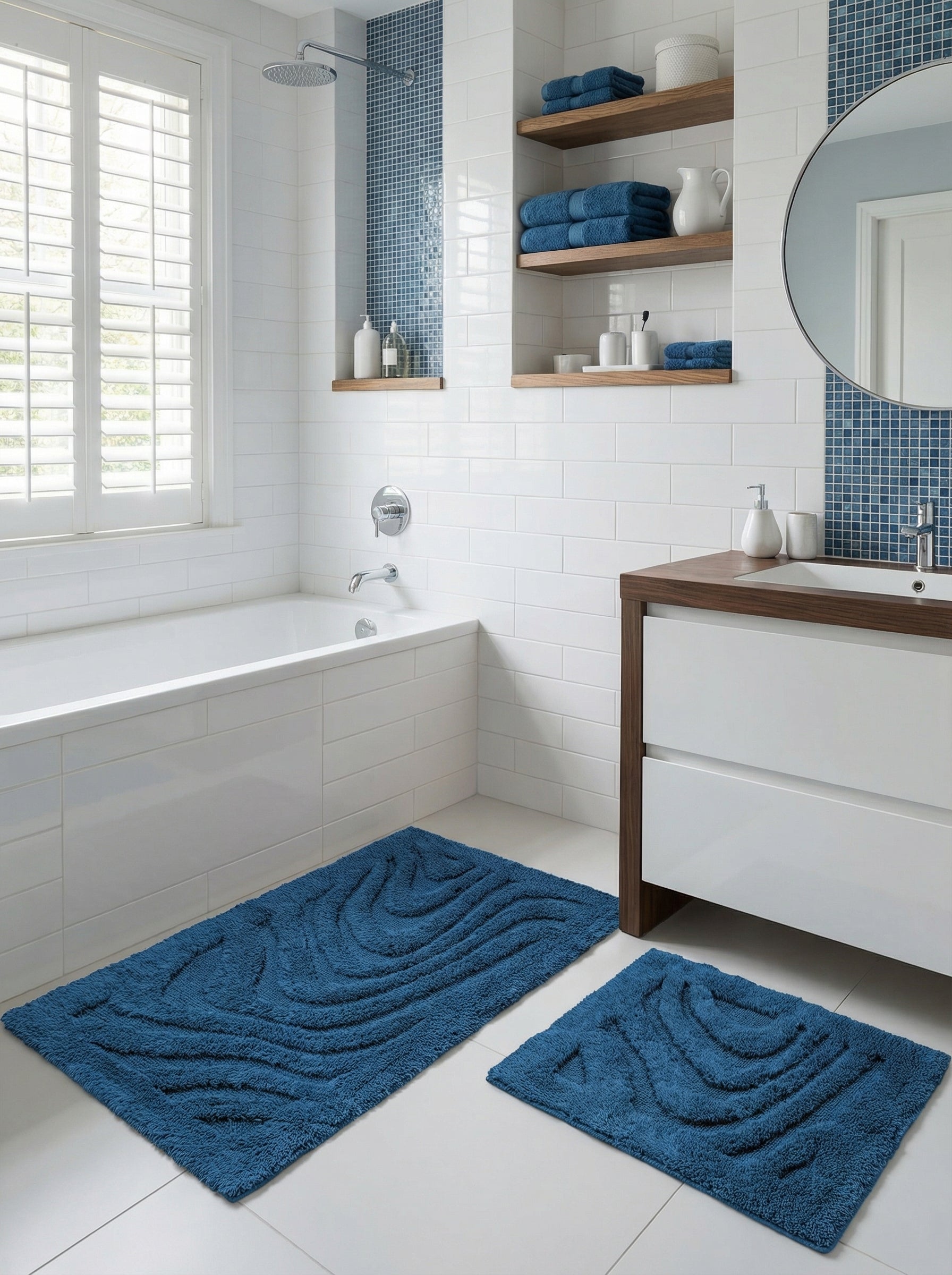 Deux tapis de bain rectangulaires bleu marine à texture bouclée et motifs ondulés en relief, sur le sol d'une salle de bain moderne