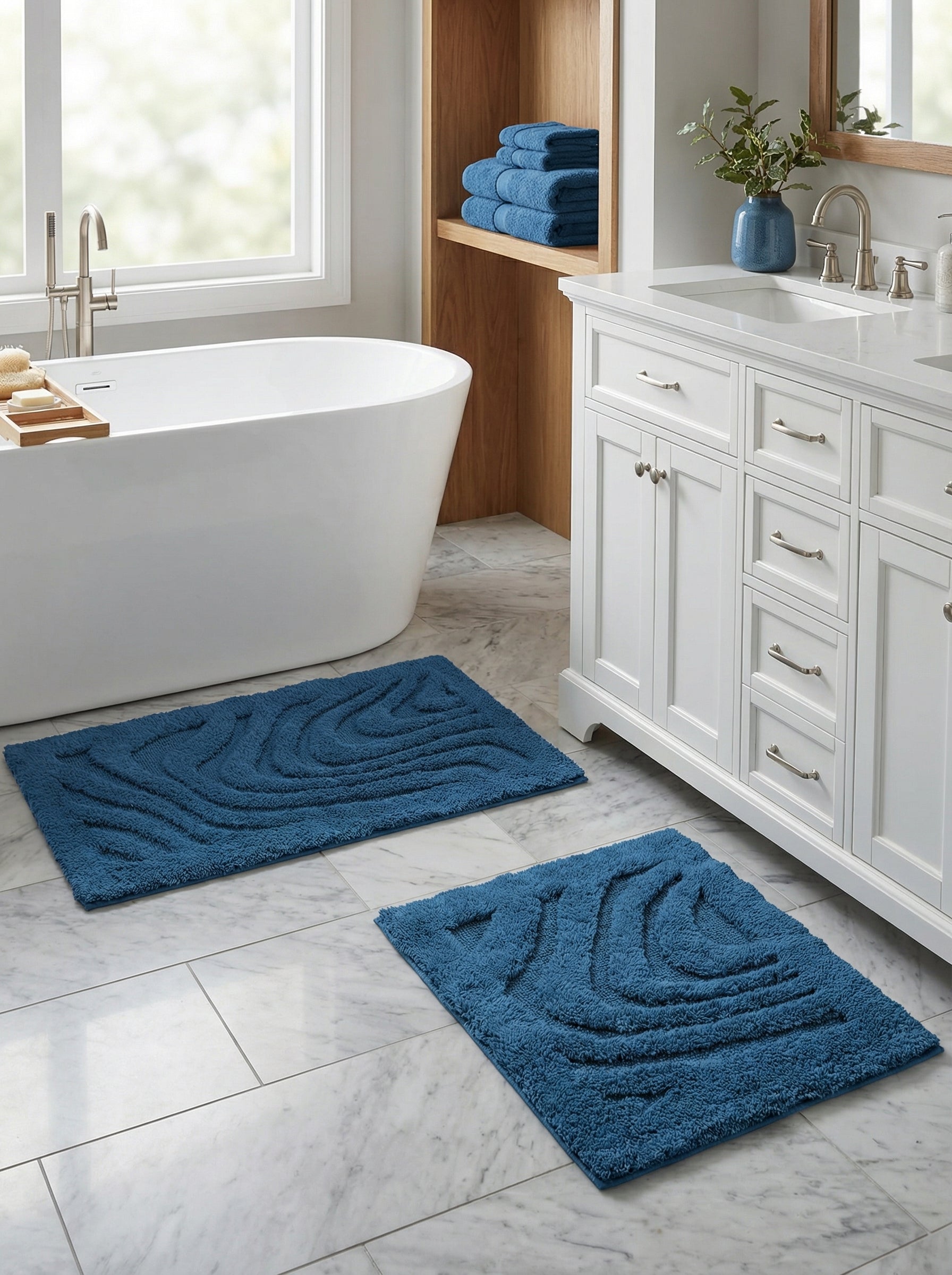 Deux tapis de bain rectangulaires bleu sarcelle à motifs de vagues en relief, sur le sol carrelé en marbre d'une salle de bain