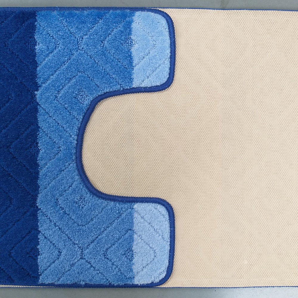 Tapis moelleux à bandes bleues dégradées, du foncé au clair, avec des motifs géométriques. Une découpe en U révèle son envers beige