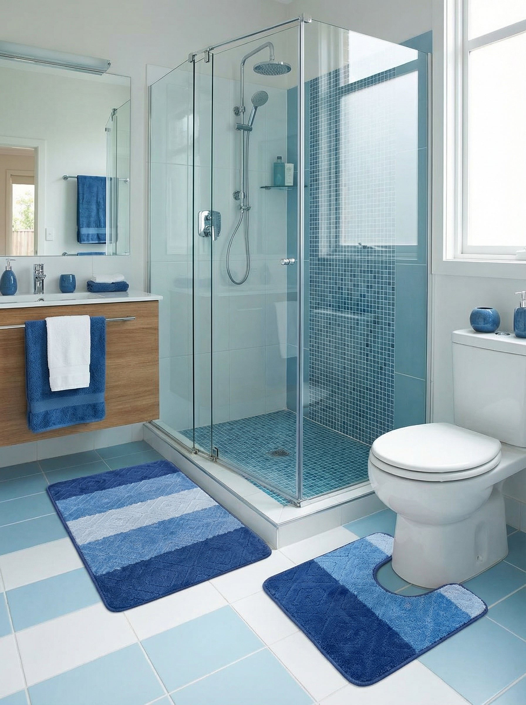 Paire de tapis de bain en tissu éponge, un rectangulaire et un en forme de U, à rayures bleu foncé, clair et blanches avec motifs texturés, posés sur un sol carrelé bicolore dans une salle de bain