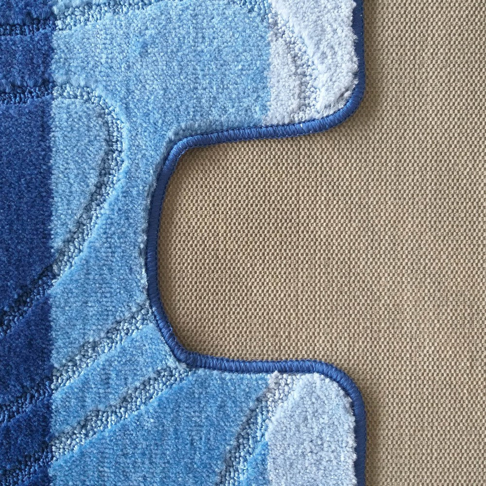 Tapis texturé bleu aux bandes de nuances variées, avec un contour ondulé foncé sur un revêtement beige