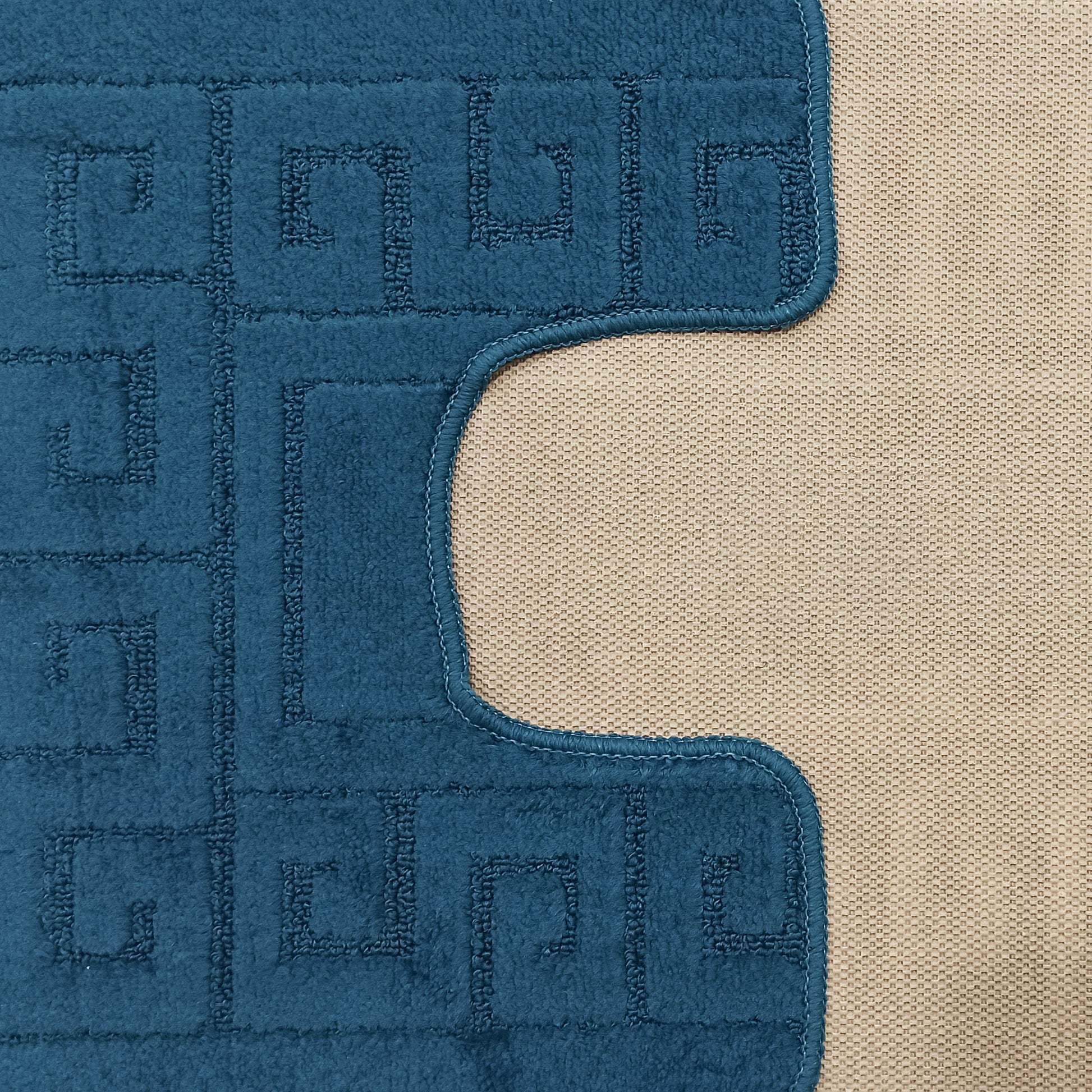 Tapis bleu sarcelle à poils courts et motifs en clé grecque, avec une bordure cousue sur un fond beige tissé