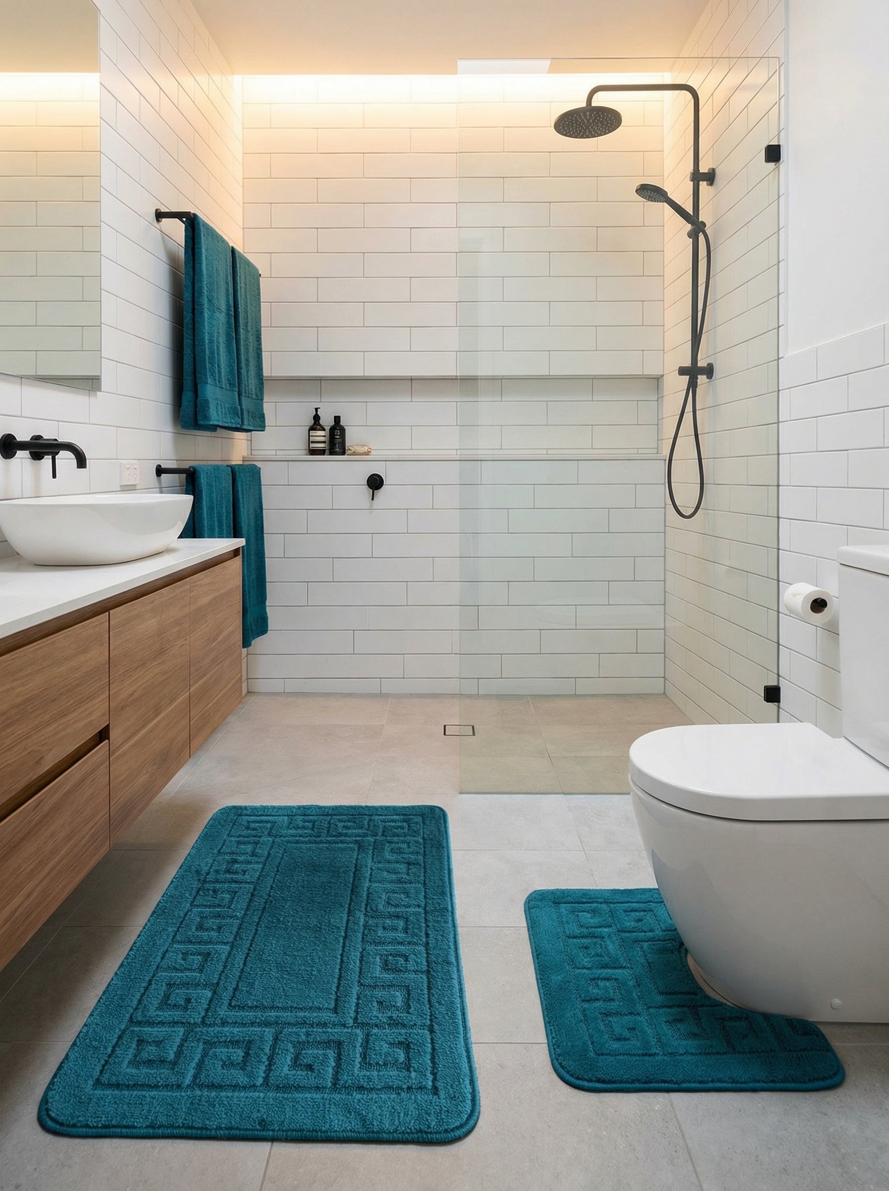 Deux tapis de bain moelleux bleu-vert à motifs géométriques, l'un rectangulaire et l'autre en forme de U, dans une salle de bain