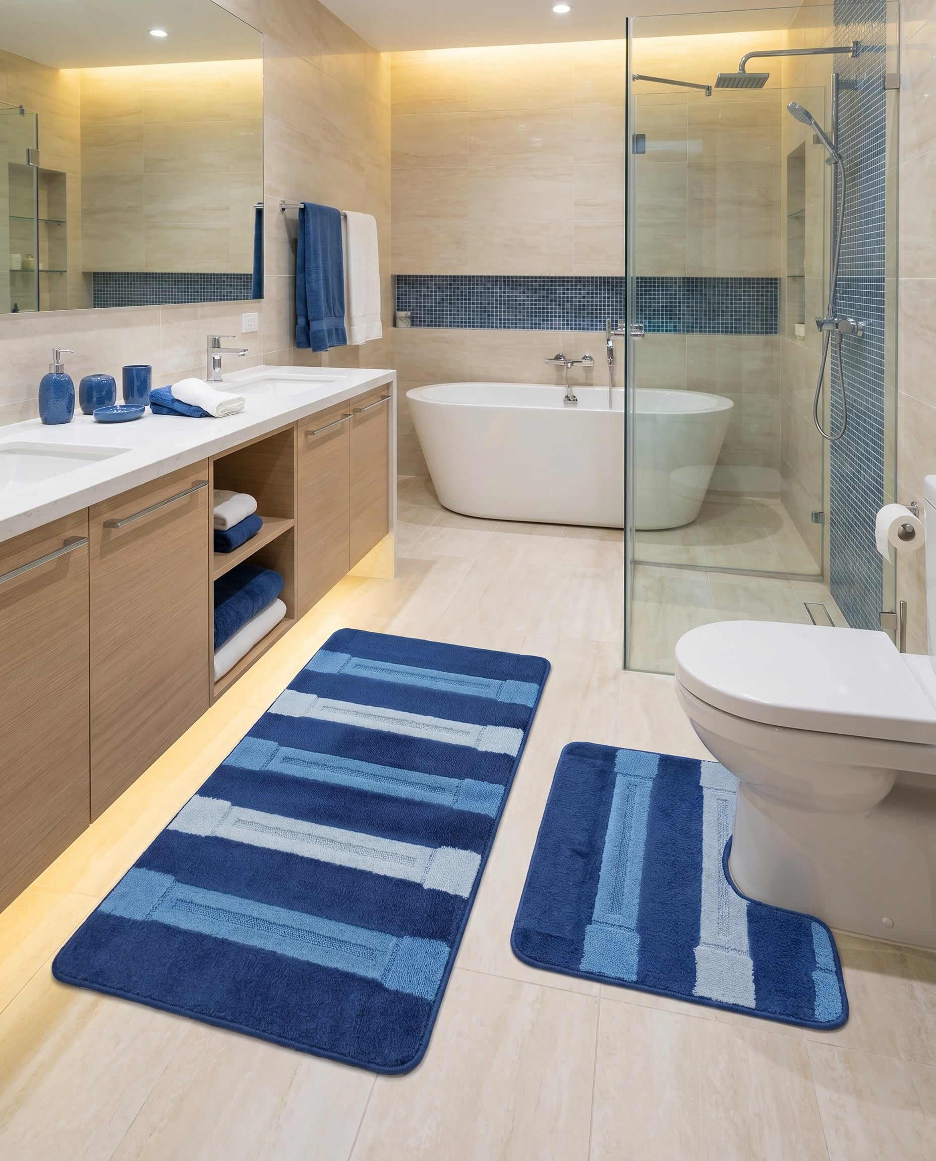 Ensemble de tapis de salle de bain en tissu éponge bleu, avec des bandes horizontales de nuances bleues variées, dans une salle de bain moderne et claire