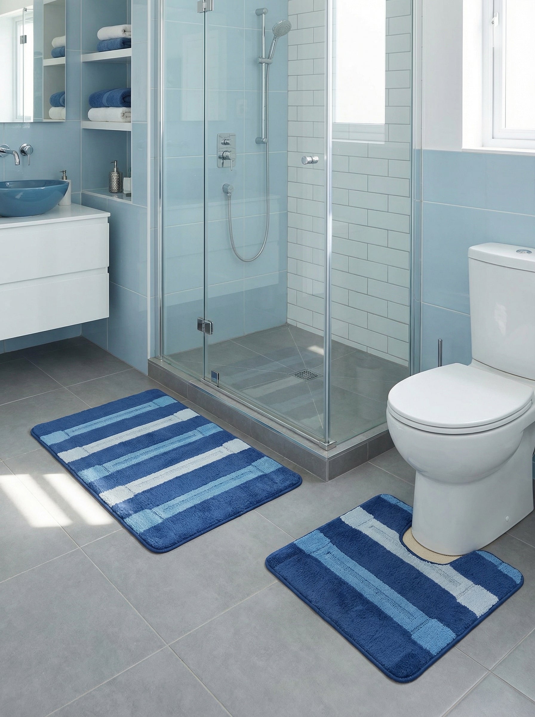 Deux tapis en tissu moelleux, rayés de bleus et blanc, l'un rectangulaire, l'autre en U, dans une salle de bain