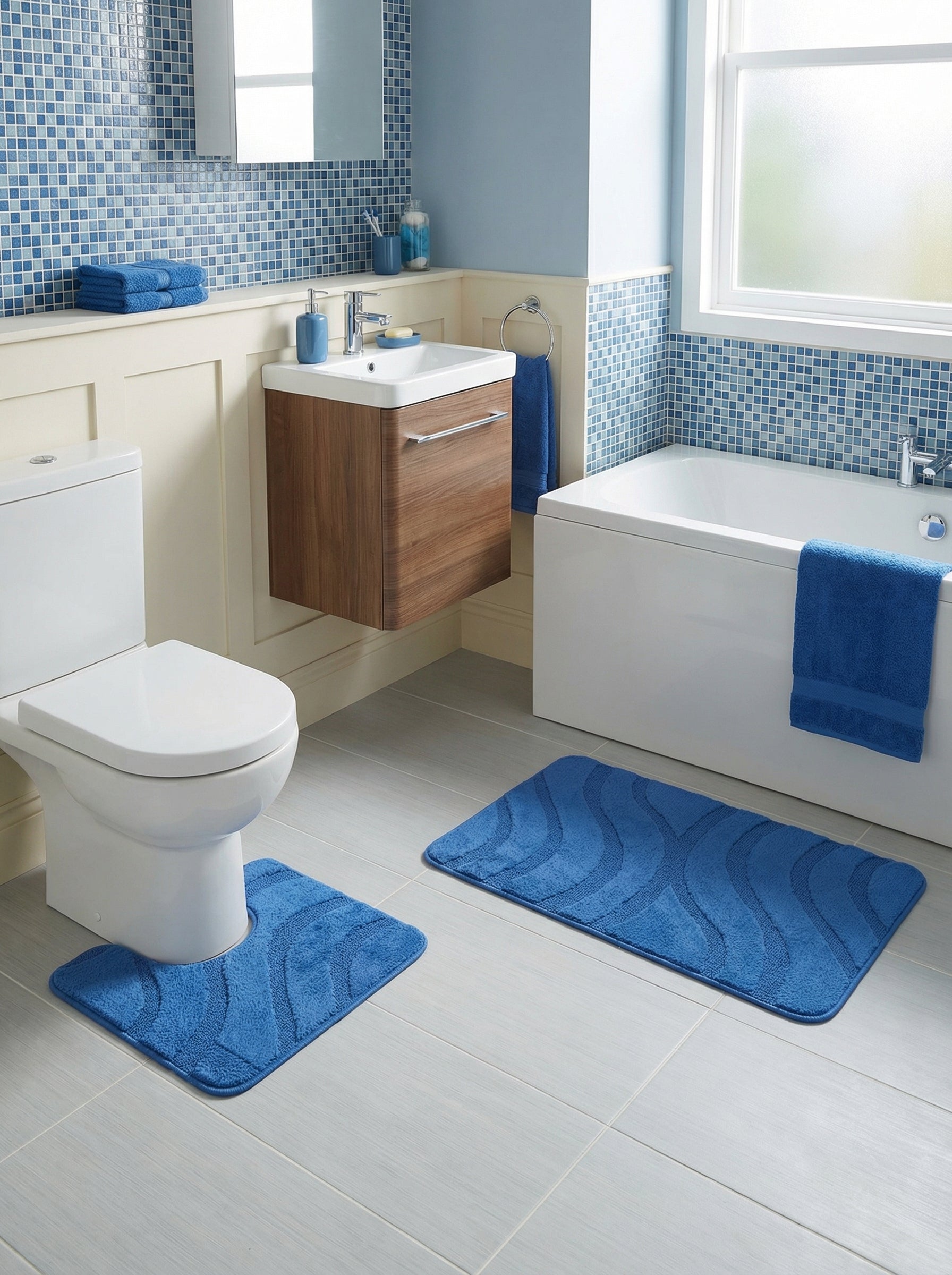 Deux tapis de bain bleus moelleux à motifs de vagues. Un rectangulaire, l'autre en U pour les toilettes d'une salle de bain moderne