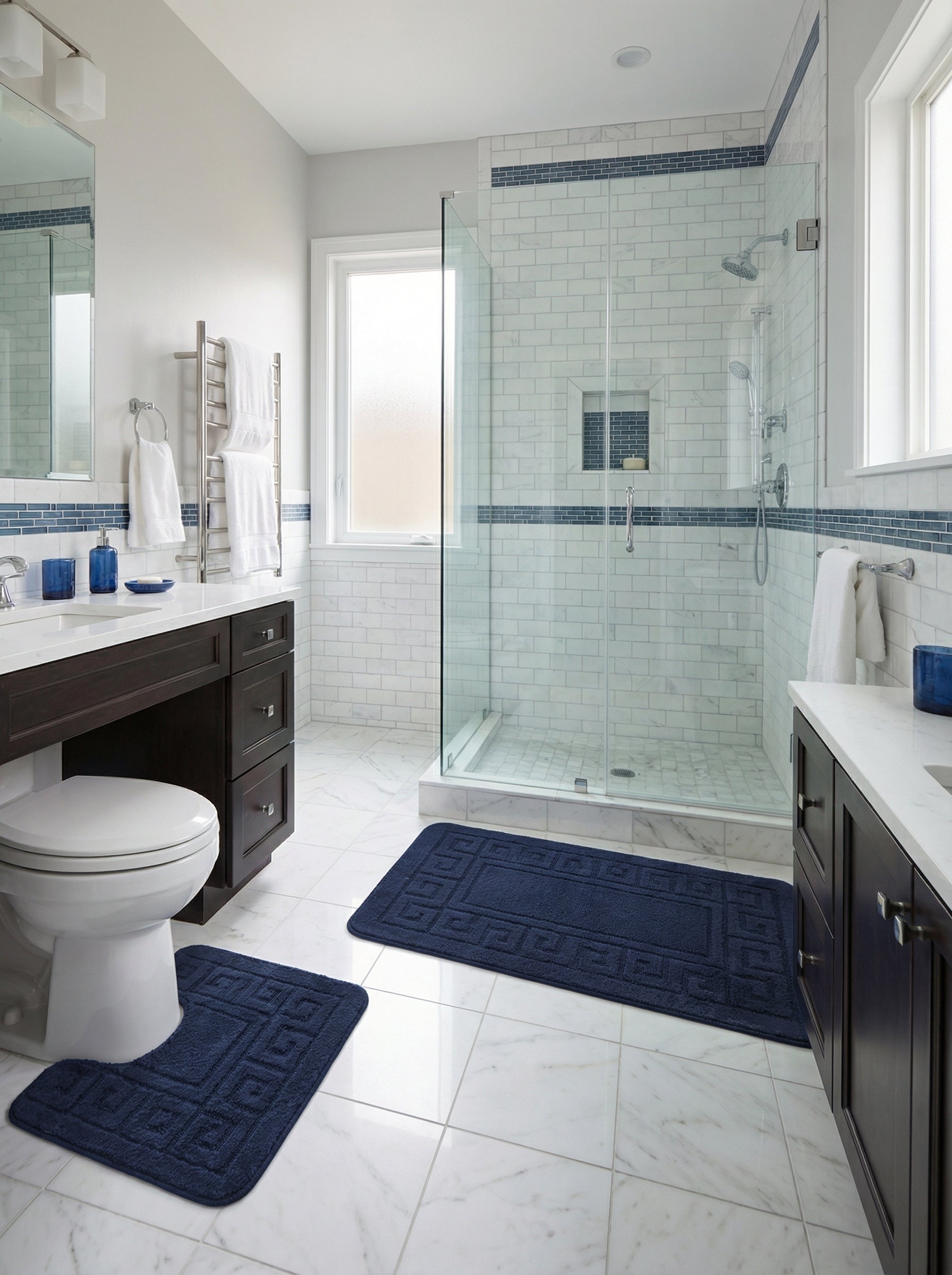 Deux tapis de bain bleu marine moelleux à motif grec méandre, un rectangulaire et un contour de toilette, dans une salle de bain claire