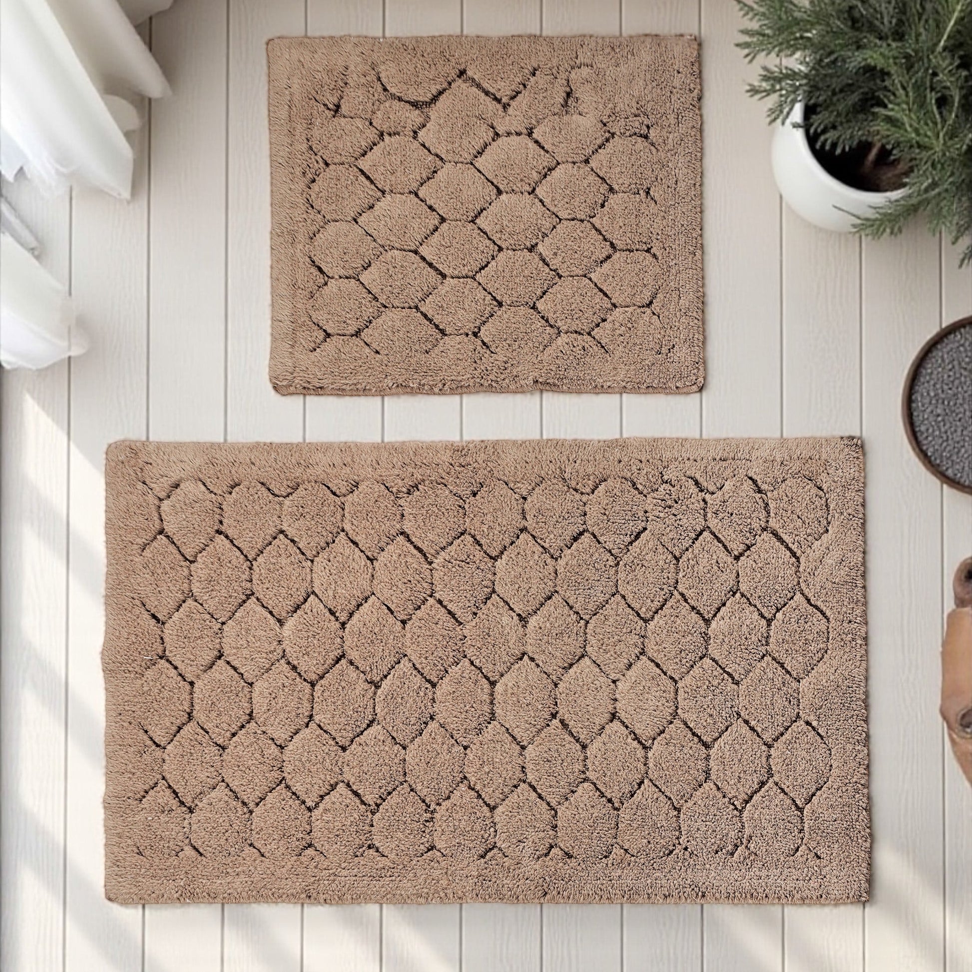 Deux tapis moelleux beige marron au motif en écailles texturées, posés sur un plancher clair