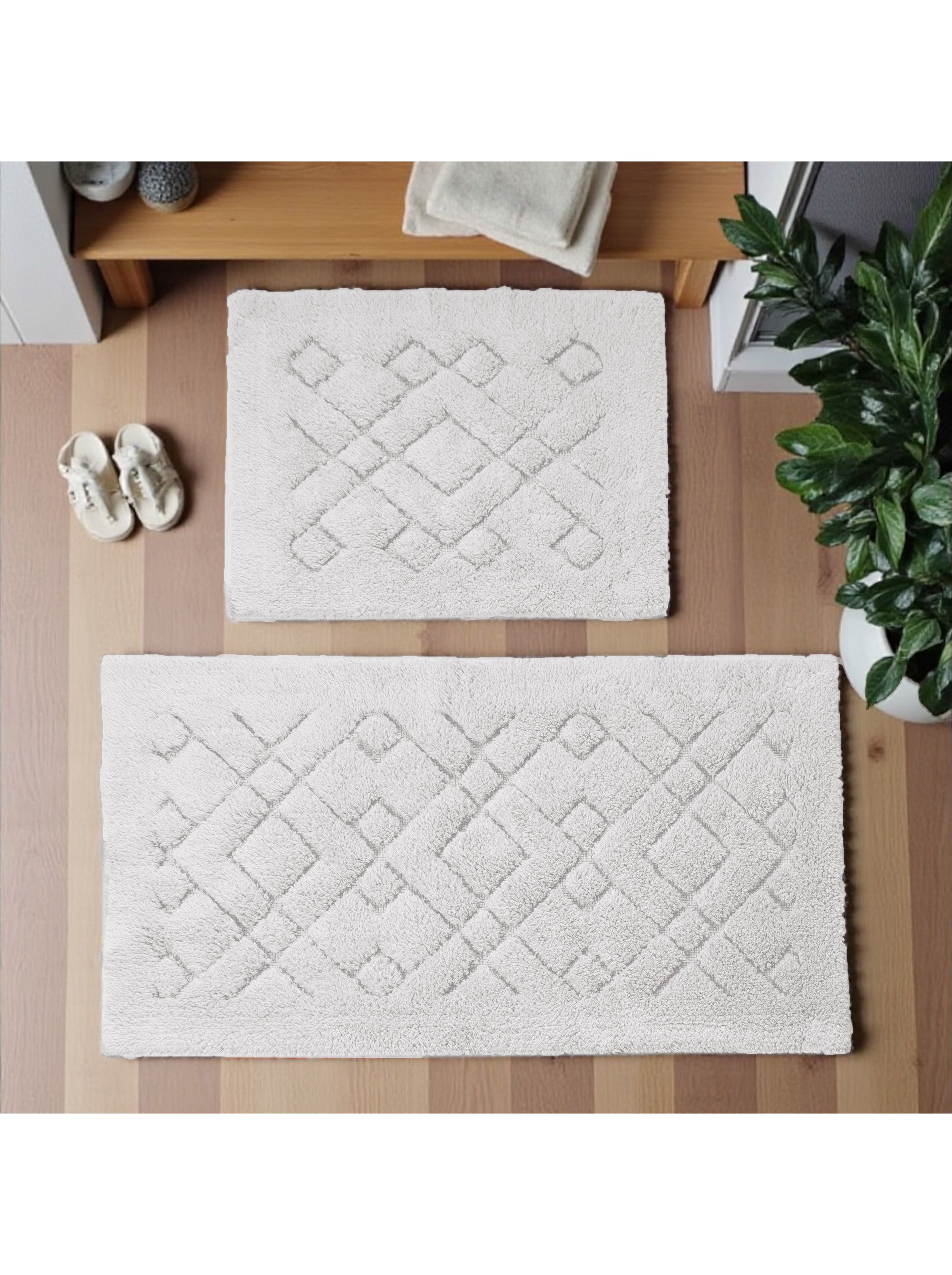 Deux tapis de sol moelleux et doux de couleur crème avec des motifs géométriques en losanges, posés sur un parquet en bois