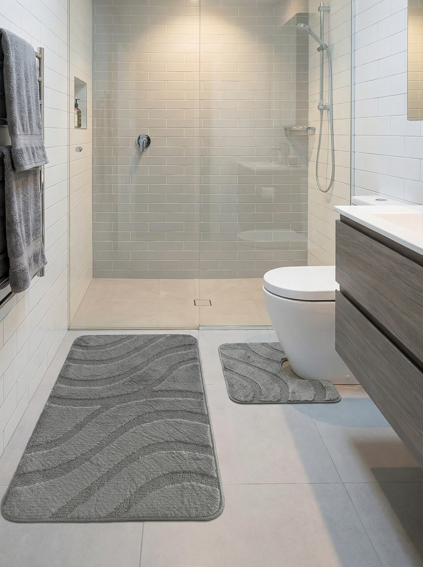 Tapis de bain rectangulaire gris à motifs de vagues texturés et un plus petit en U assorti dans une salle de bain moderne