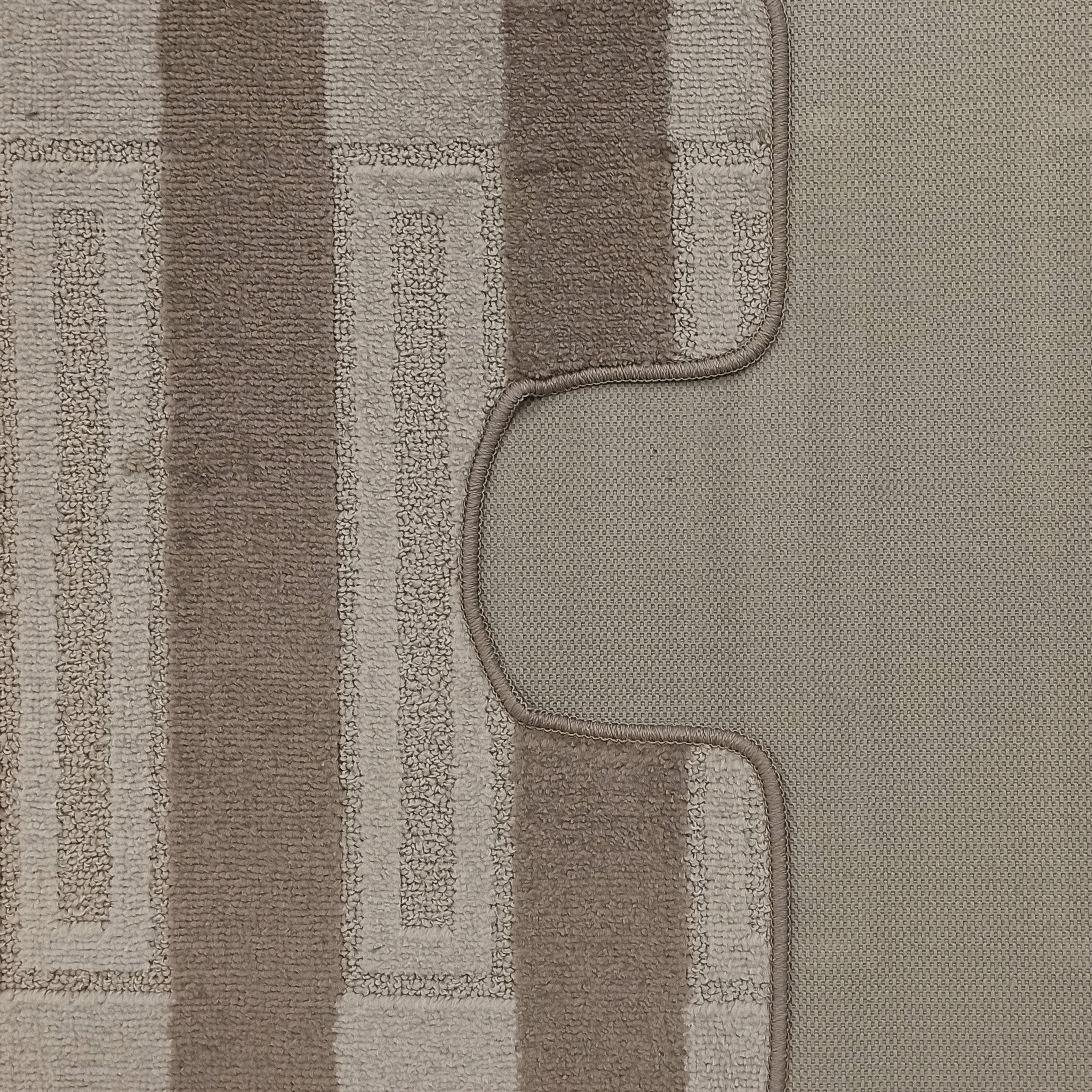 Tapis à boucles texturées beige et marron avec motif géométrique. L'envers tissé gris-beige avec une bordure cousue est visible