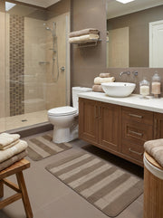 Tapis de bain aux motifs rayés beige clair et brun foncé, avec des textures variées, dans une salle de bain moderne