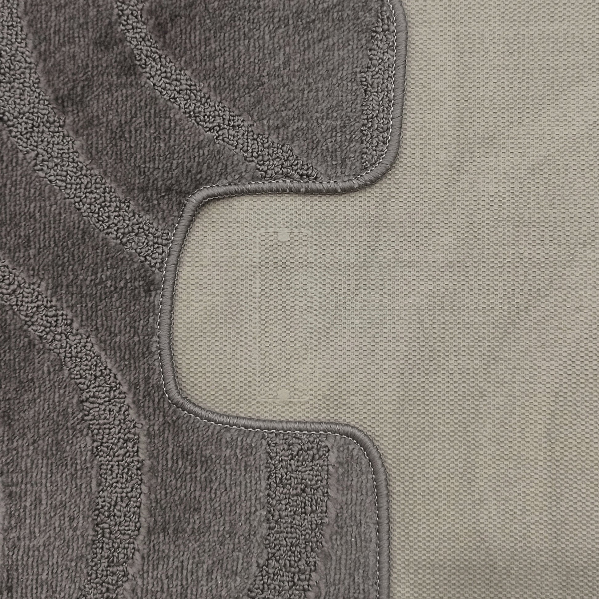 Tapis bicolore gris avec une section en bouclettes épaisses et des motifs ondulés en relief, bordé d'une zone tissée plus claire