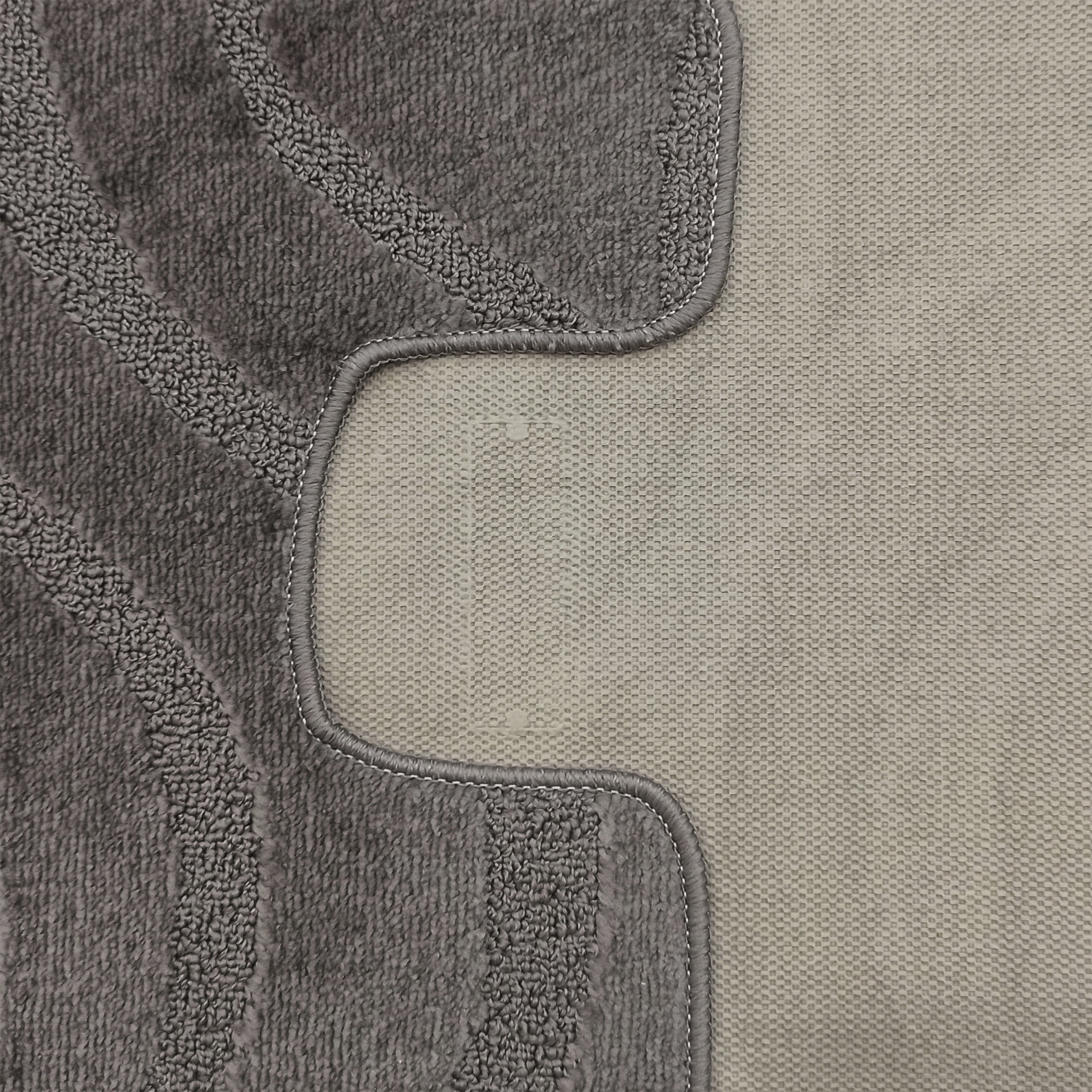 Tapis bicolore gris avec une section en bouclettes épaisses et des motifs ondulés en relief, bordé d'une zone tissée plus claire