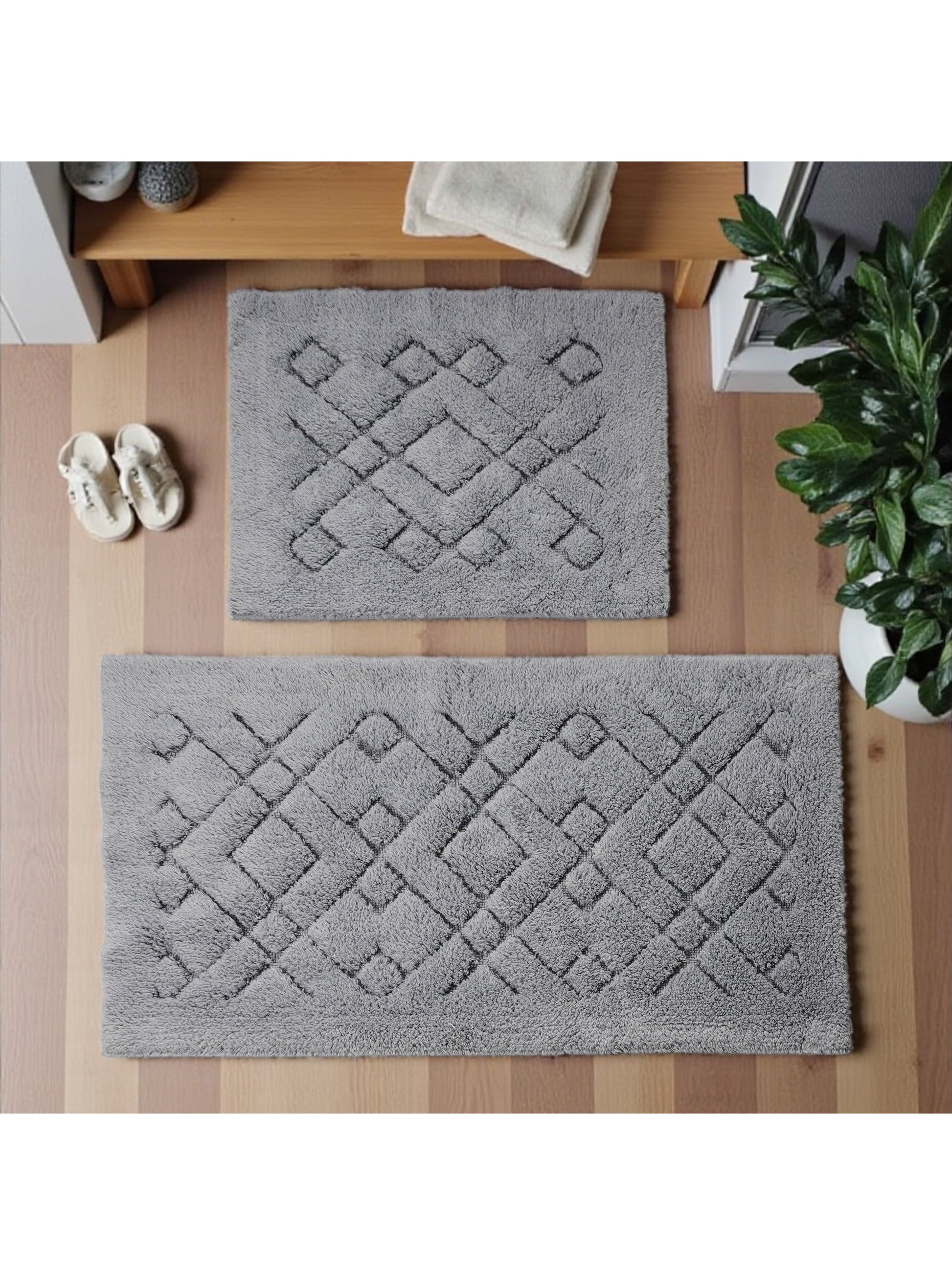 Deux tapis gris à texture douce et motif géométrique de losanges en relief sur un parquet clair