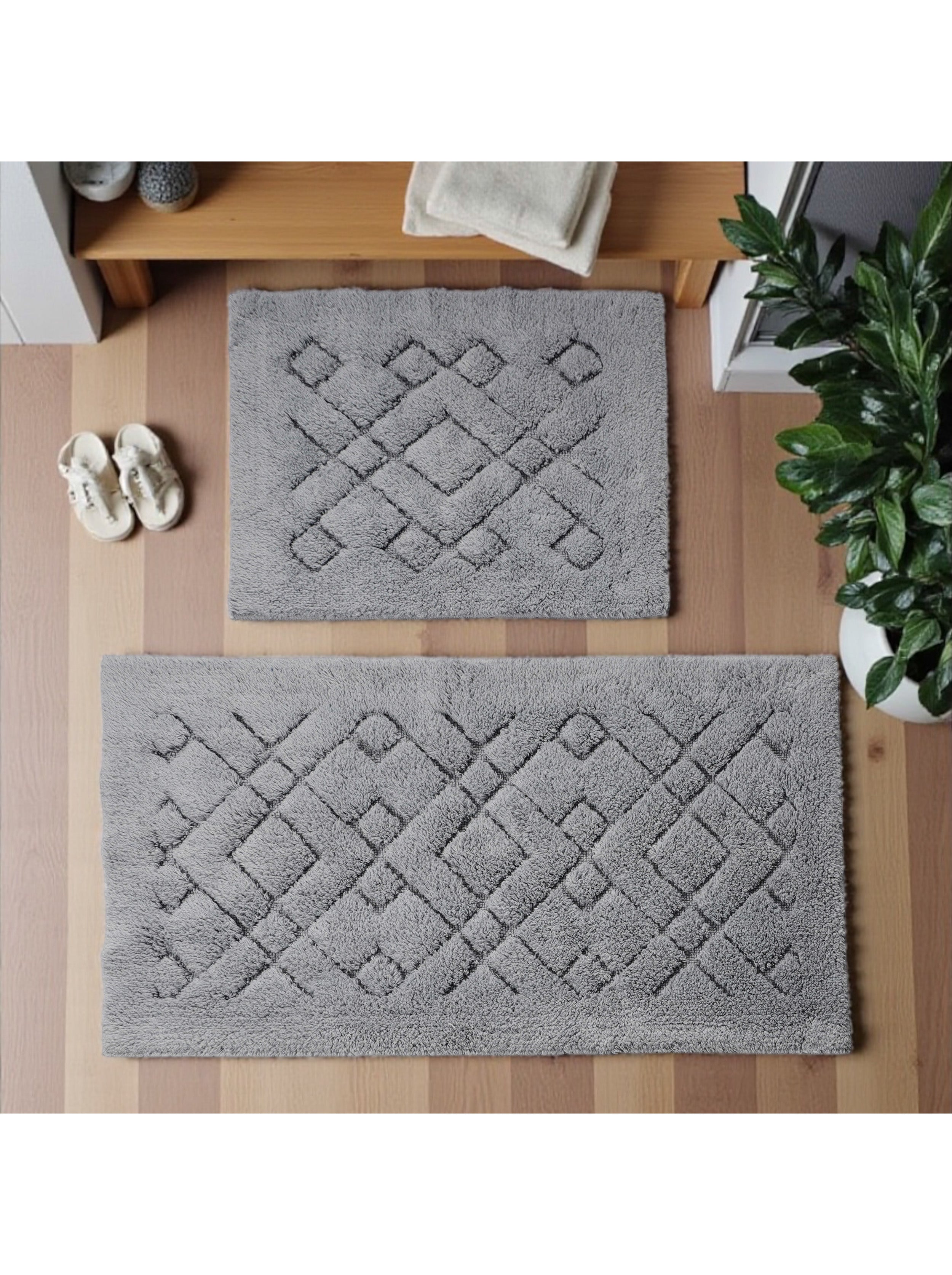 Deux tapis gris à texture douce et motif géométrique de losanges en relief sur un parquet clair