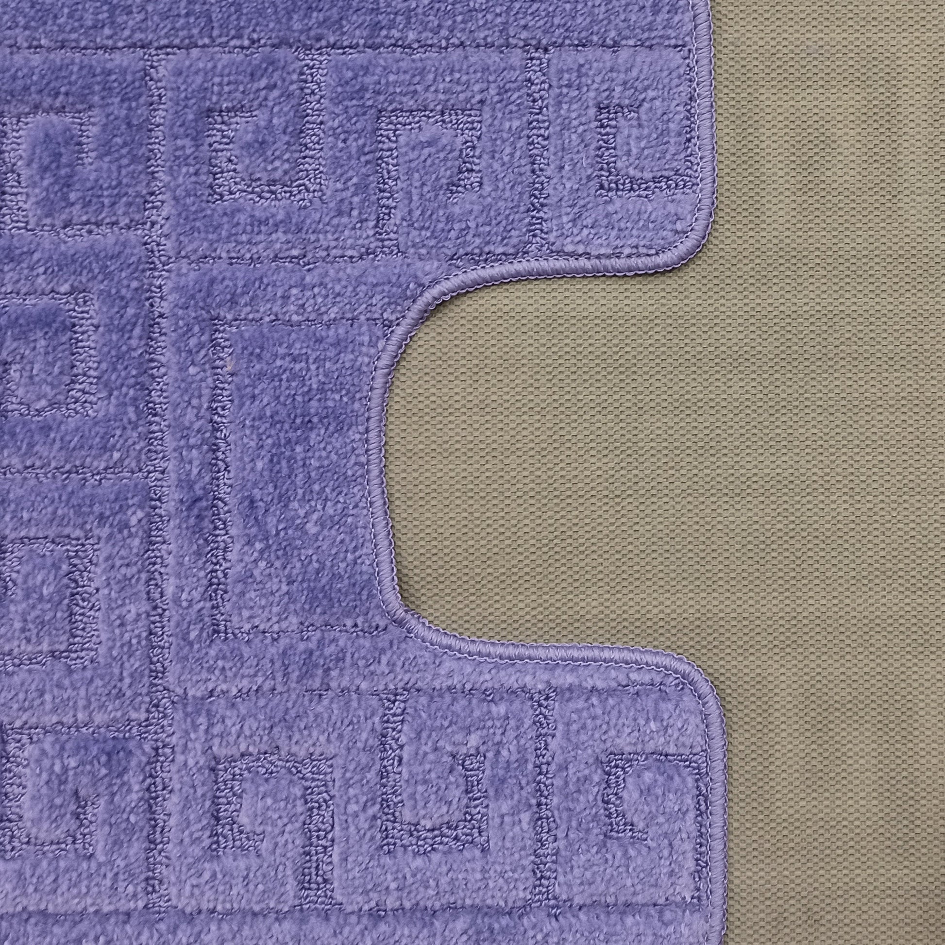 Tapis doux violet lavande avec un motif géométrique en relief et une bordure courbée sur un fond beige texturé
