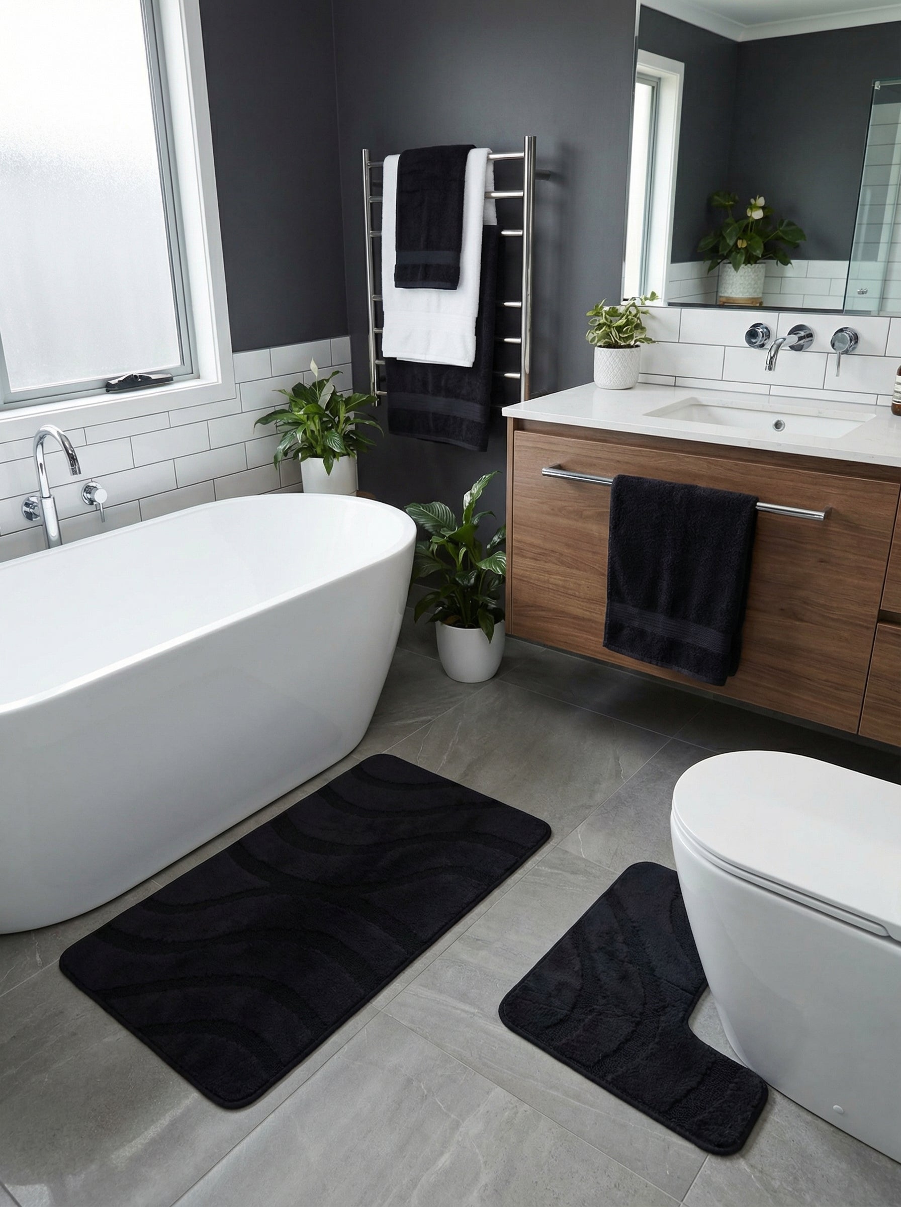 Tapis de bain noirs rectangulaire et en U avec motifs ondulés texturés, posés sur un sol gris dans une salle de bain moderne
