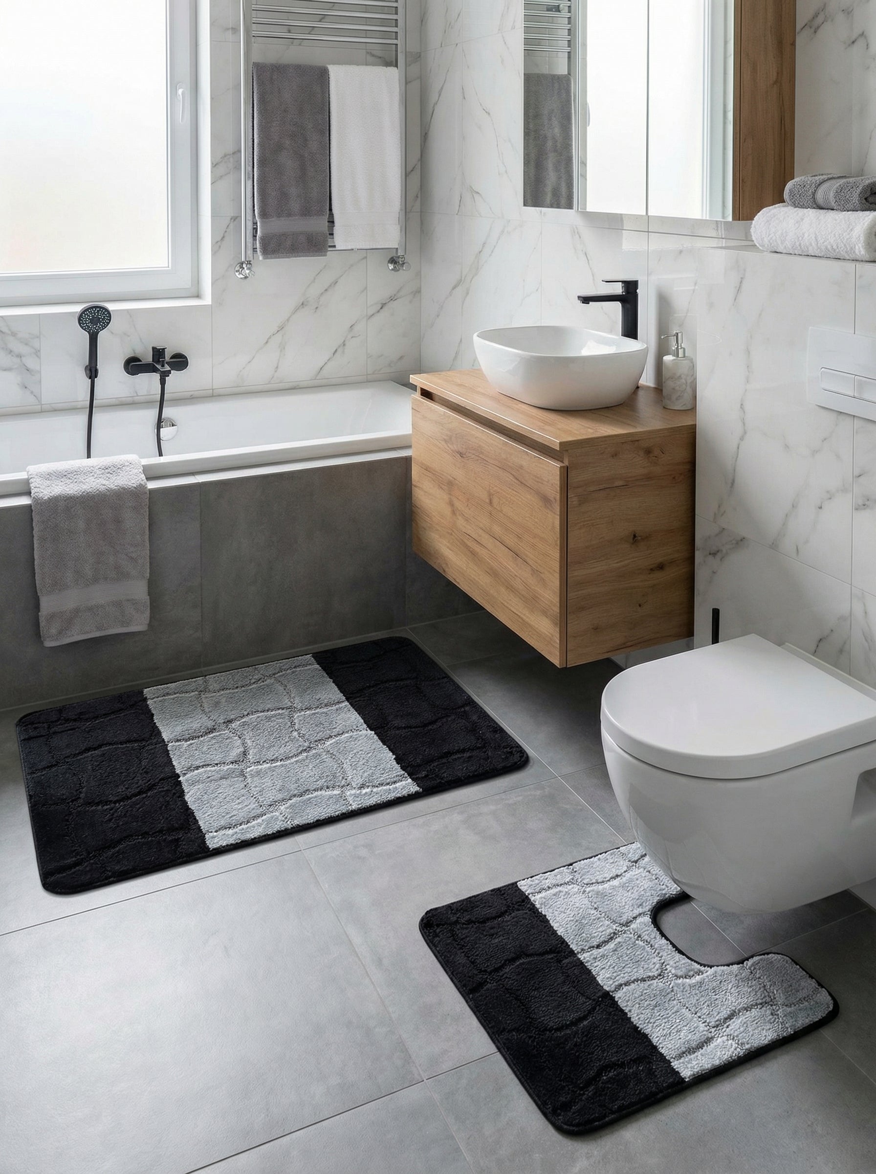 Tapis de bain doux noir et gris clair à motifs texturés, en deux pièces dont une en U, dans une salle de bain moderne