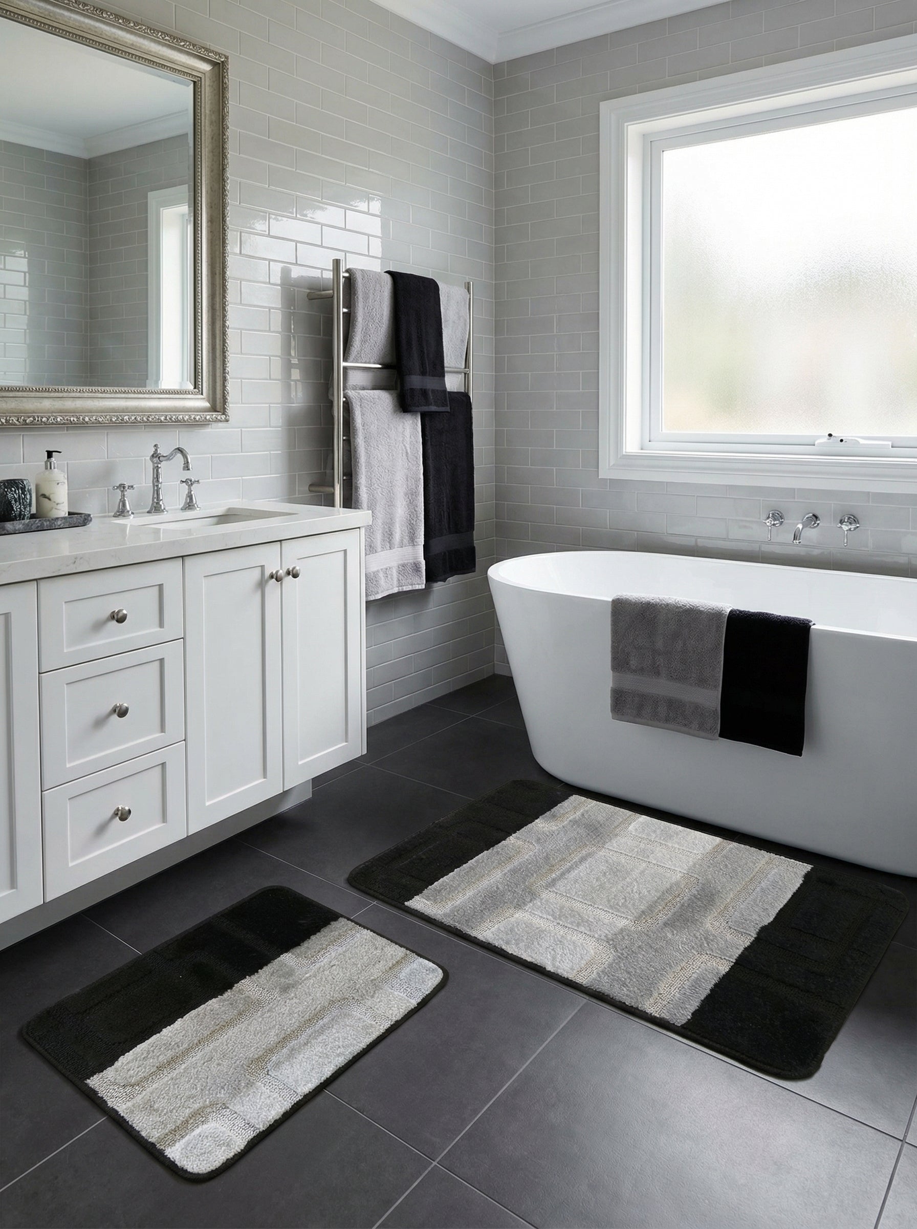 Paire de tapis de bain rectangulaires, noirs aux extrémités et avec un motif central texturé gris clair à rayures et carrés, dans une salle de bain