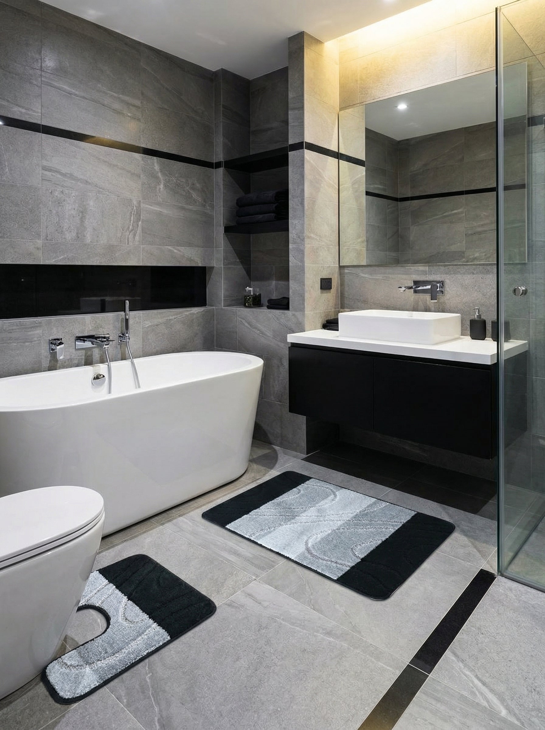 Tapis de bain moelleux noir et gris clair avec des motifs ondulés abstraits, dans une salle de bain carrelée moderne