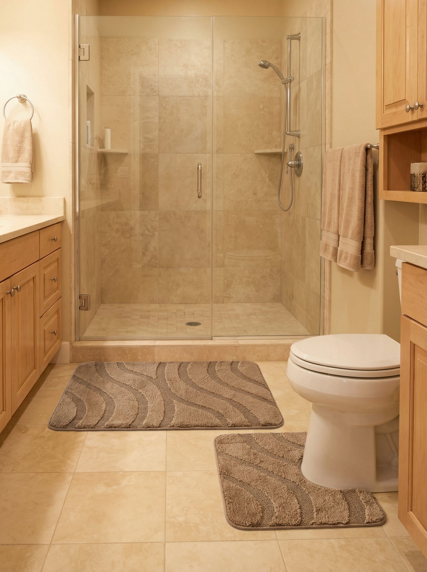 Deux tapis de bain taupe en tissu doux, l'un rectangulaire, l'autre en U, aux motifs ondulés en relief, dans une salle de bain