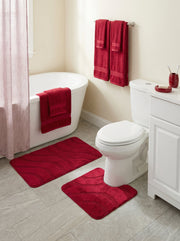 Ensemble de tapis de bain rouges moelleux à motifs de vagues subtiles, un rectangulaire et un contour toilettes, dans une salle de bain