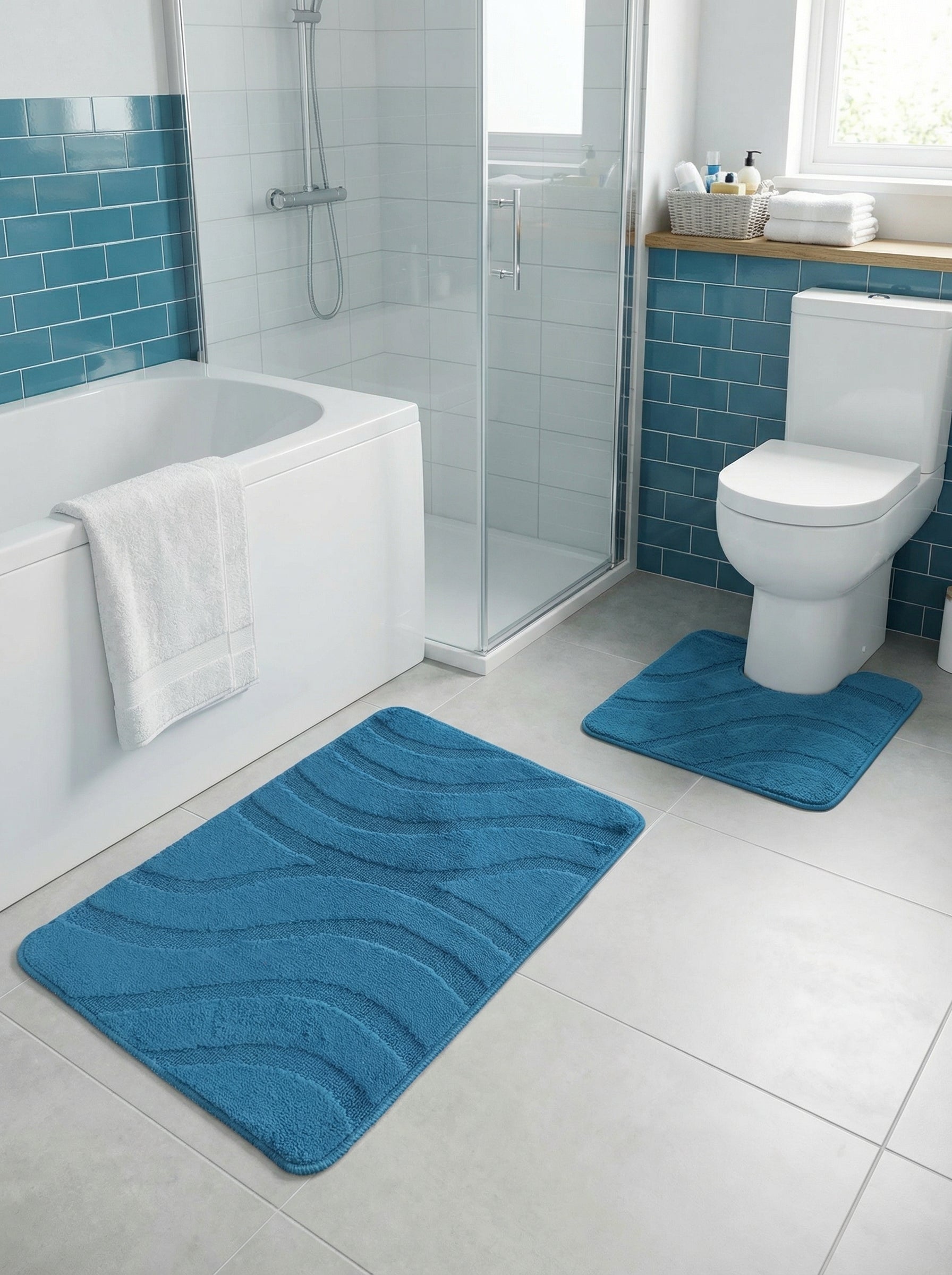 Tapis de bain bleus à motifs de vagues, l'un rectangulaire, l'autre en U devant les toilettes d'une salle de bain