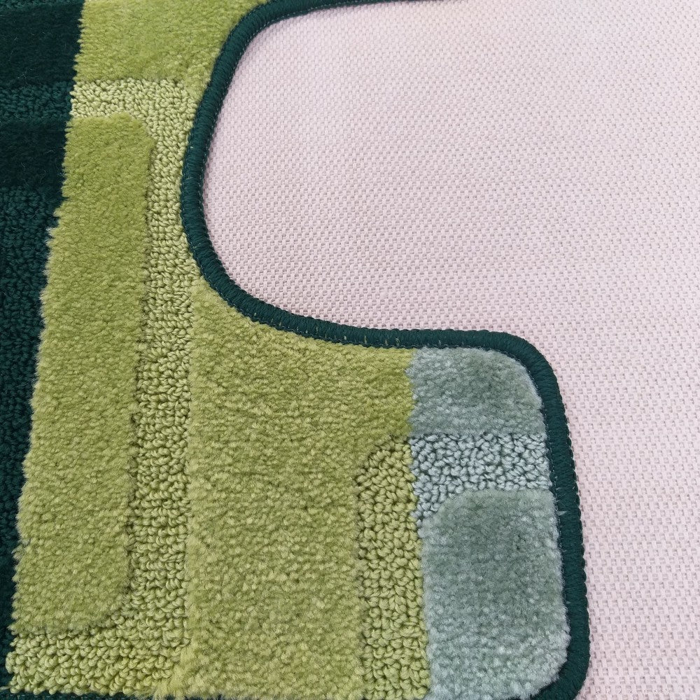 Tapis aux rayures irrégulières de différentes nuances de vert et textures variées, bordé de vert foncé sur un sol rose clair
