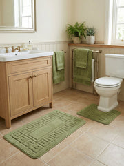 Tapis de bain rectangulaire vert clair en coton bouclé avec un motif géométrique en relief, sur le sol d'une salle de bain