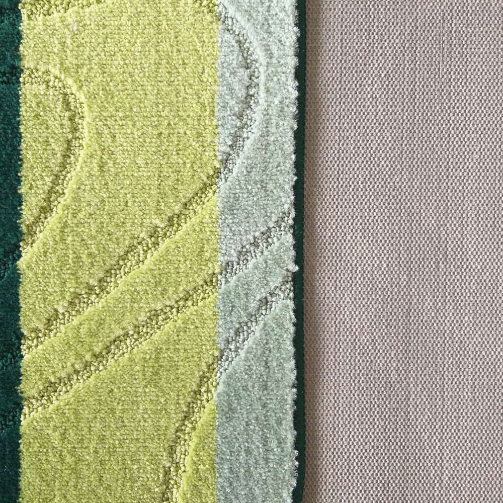 Tapis épais aux motifs abstraits ondulés en vert foncé, vert anis et vert clair, à côté d'une surface textile beige