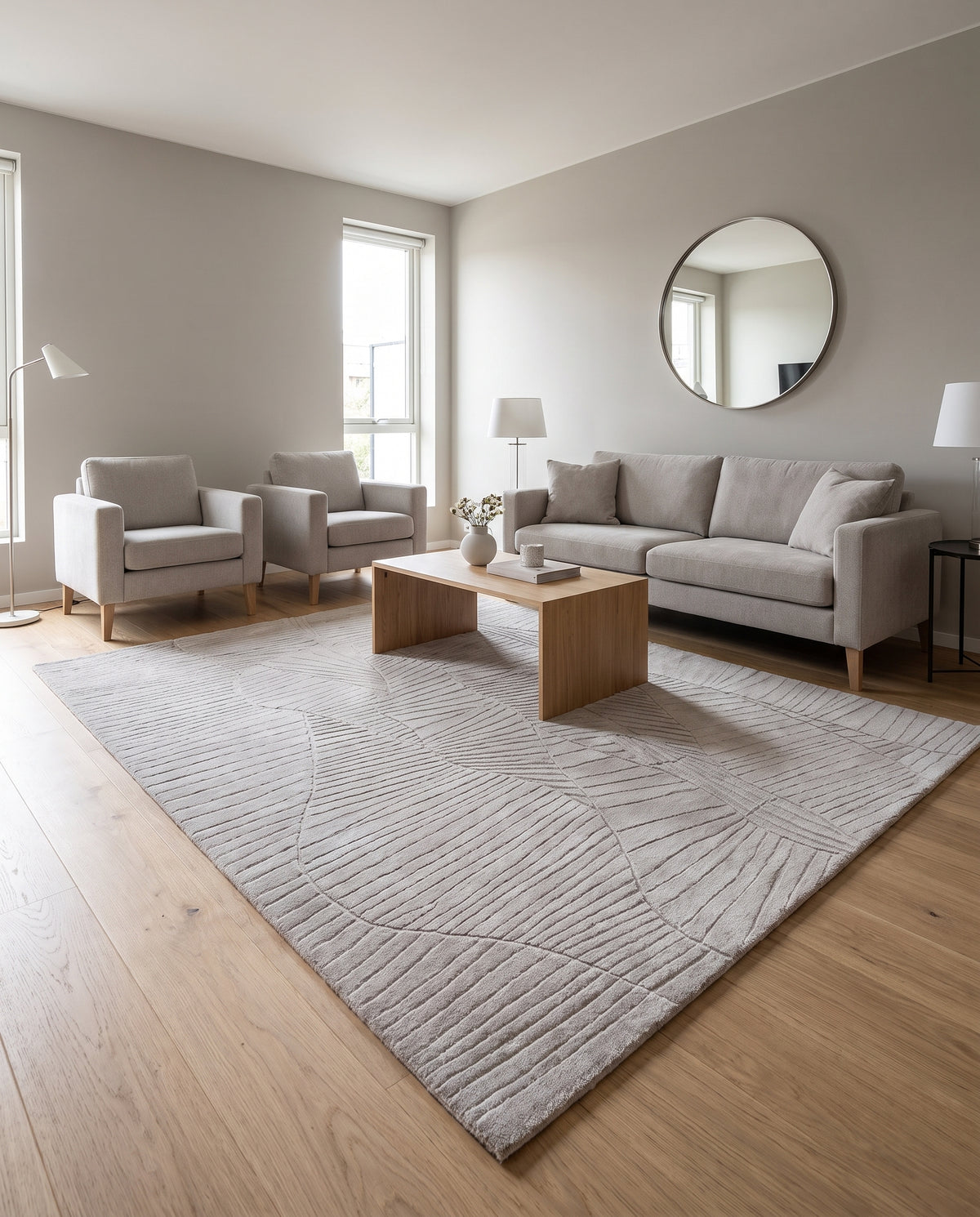 Sculpté de lignes courbes et parallèles, ce tapis en laine beige grège enrichit un salon contemporain