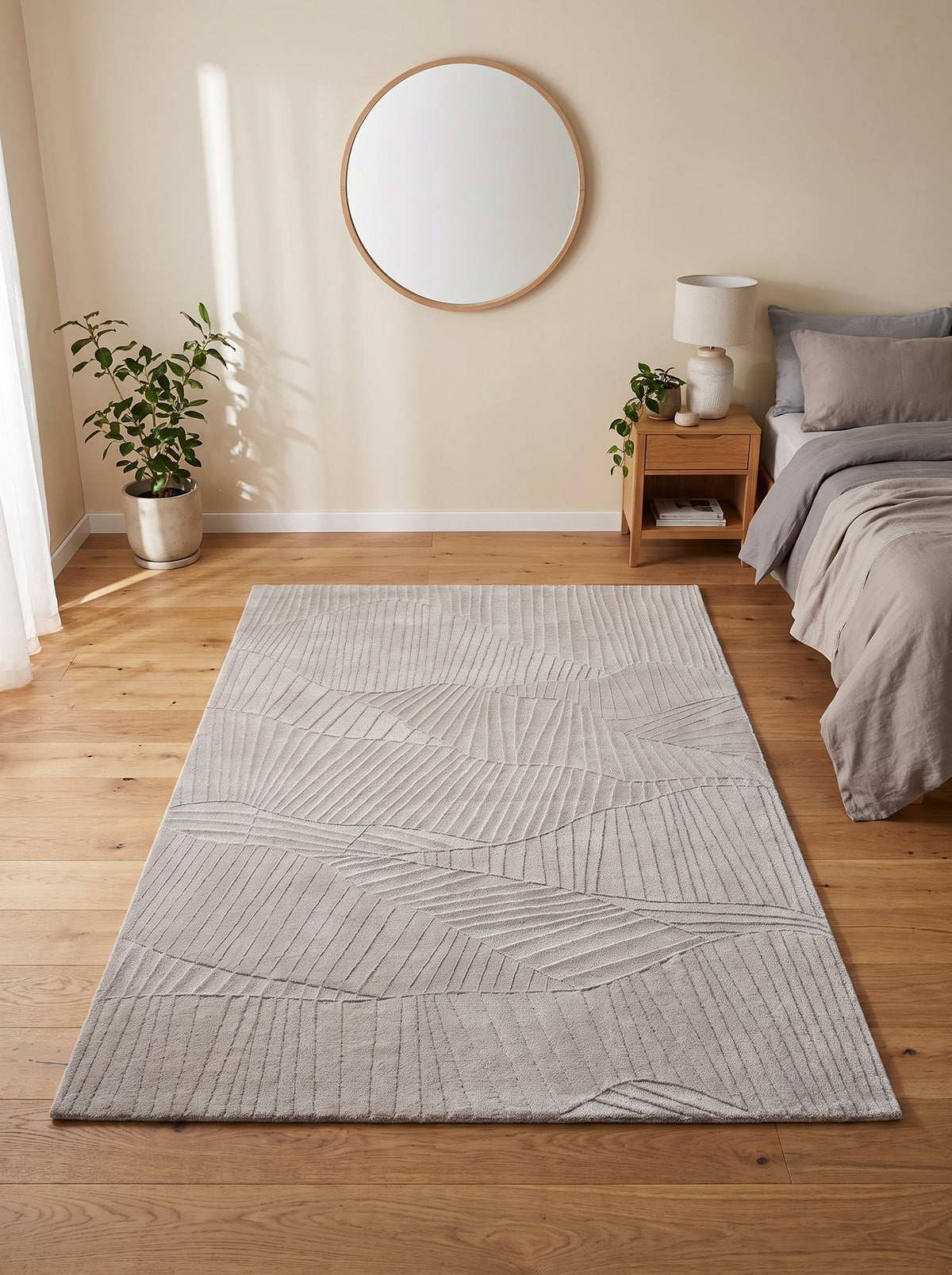 Reliefs abstraits et lignes entrelacées ornent ce tapis rectangulaire en laine beige grège, posé dans une chambre lumineuse