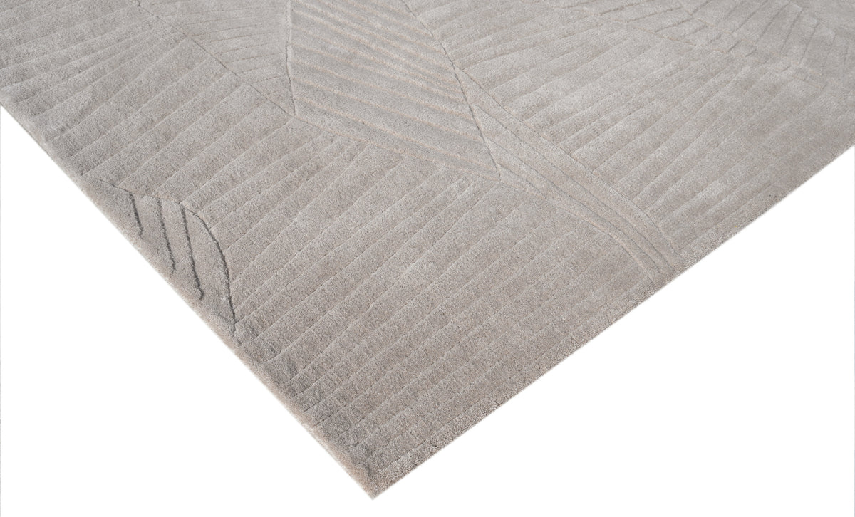 Les motifs abstraits sculptés en profondeur révèlent la texture du velours de laine beige grège