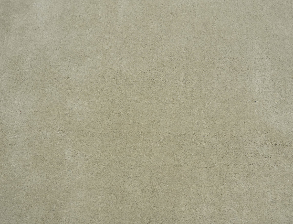 La matière moelleuse et le relief délicat de la laine beige sable d'un tapis fait main, vus de près