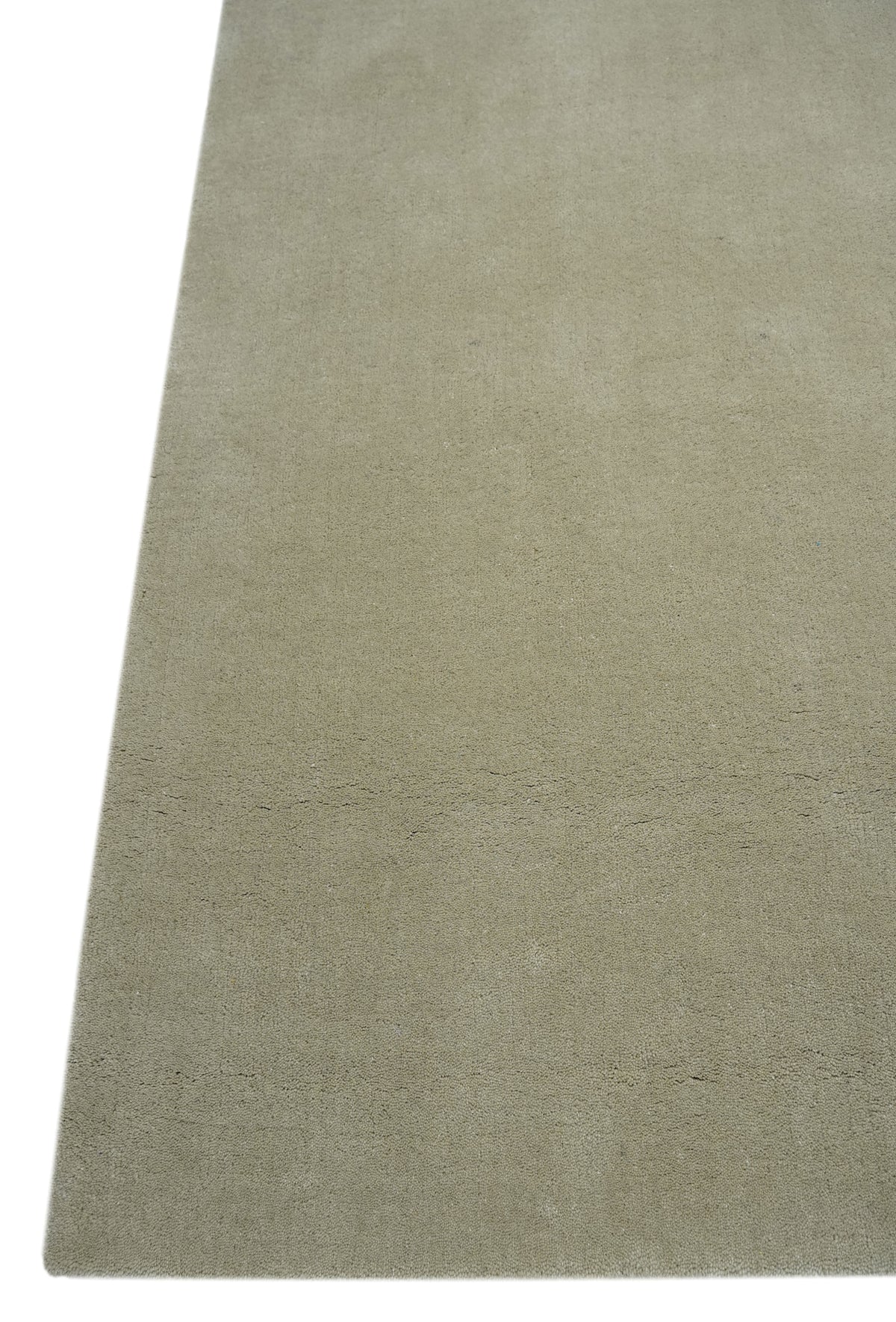De près, la surface en laine beige sable d'un tapis fait main révèle un délicat relief