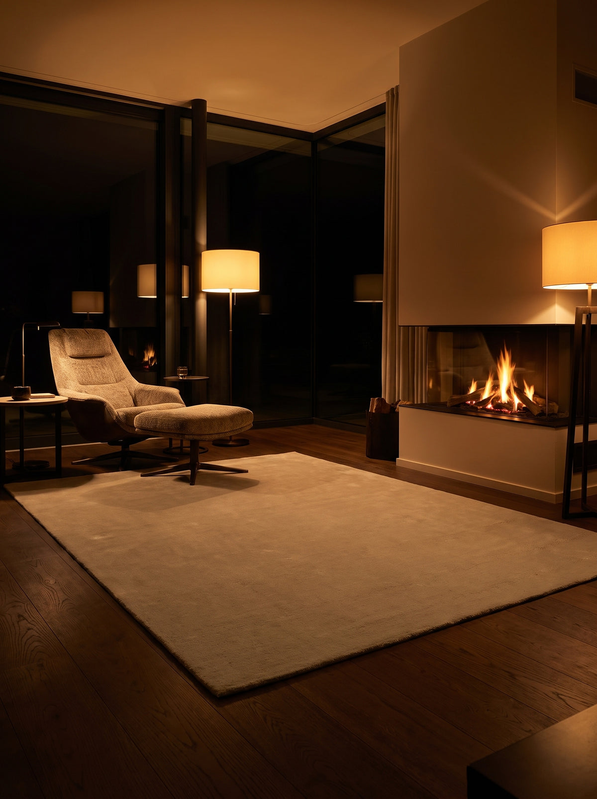 Dans un salon de nuit chaleureux, un tapis fait main en laine beige sable rectangulaire offre une surface unie et moelleuse