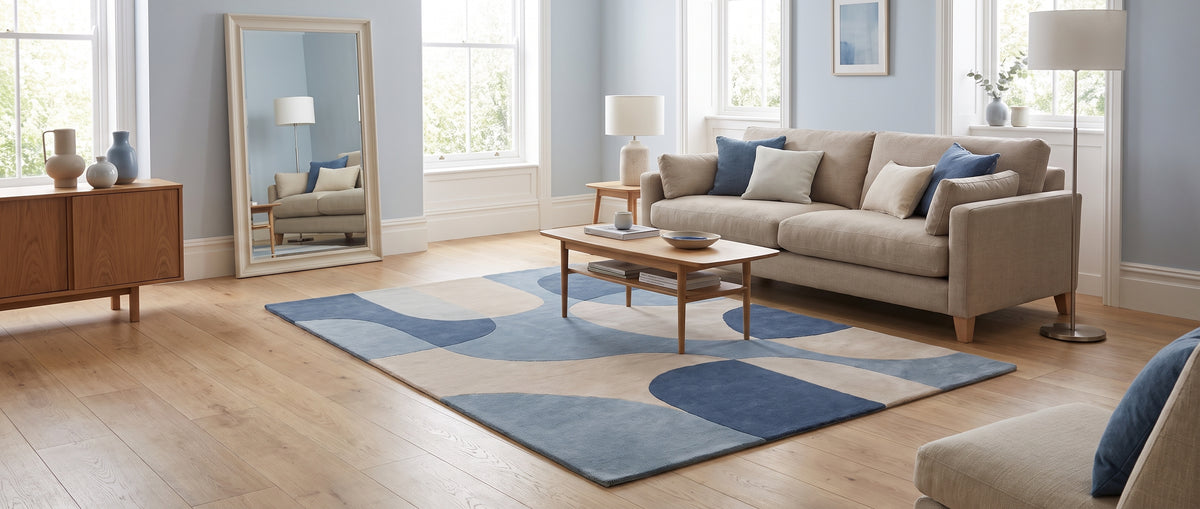 Dans un salon lumineux, un tapis de laine velours coupé expose des courbes bleues et beiges