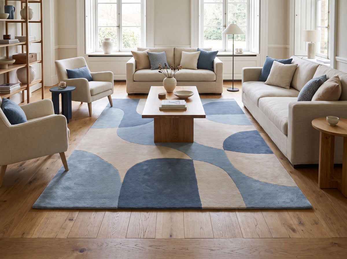 Courbes imbriquées de bleu marine, bleu clair et beige sur un tapis de laine au sol d'un salon
