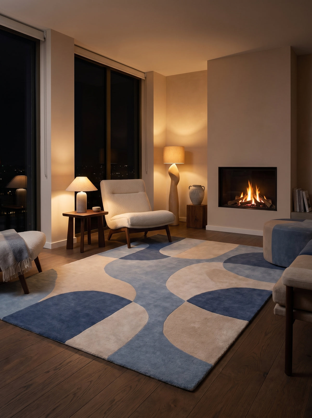 De grandes courbes imbriquées bleues et beiges forment ce tapis rectangulaire en laine, au sol d'un salon de nuit
