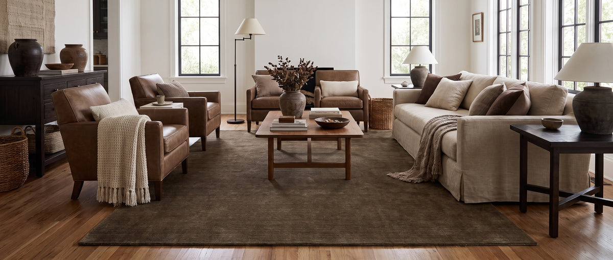 Au velours de laine fait main, brun foncé et texturé, ce grand tapis rectangulaire sublime ce salon chic