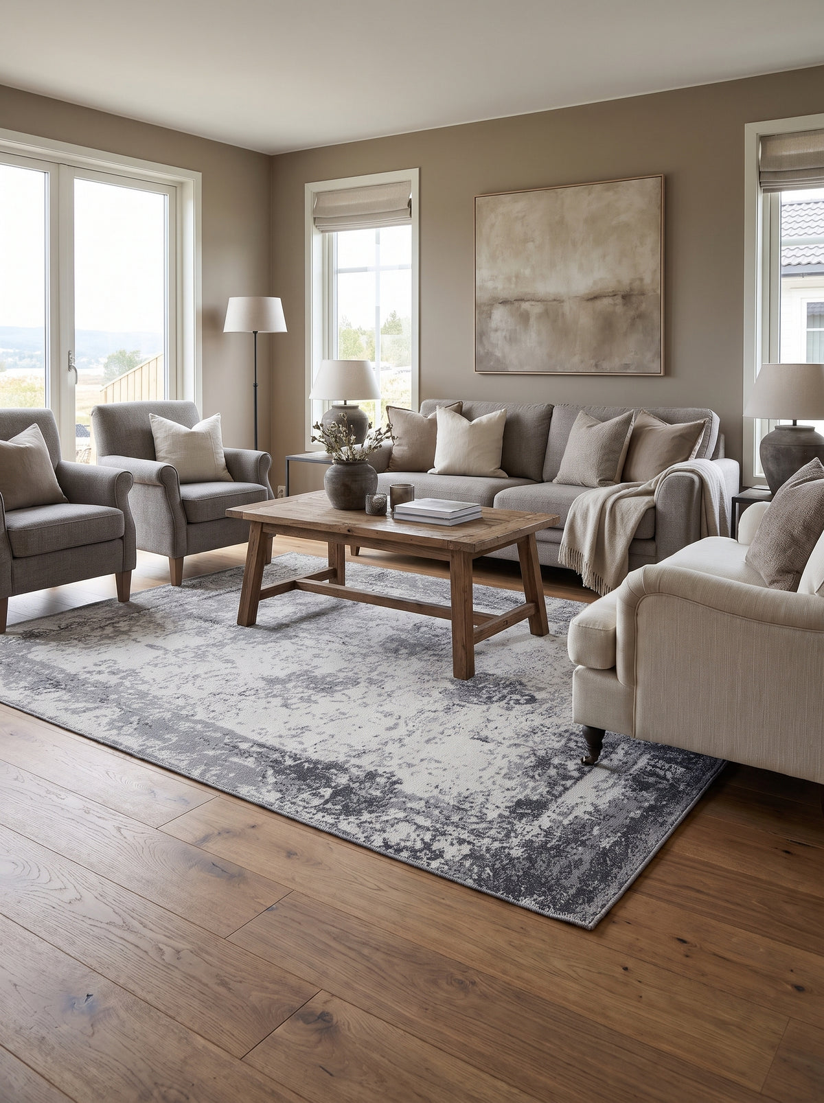 La laine naturelle d'un tapis fait main, gris et ivoire aux motifs abstraits, réchauffe ce salon lumineux
