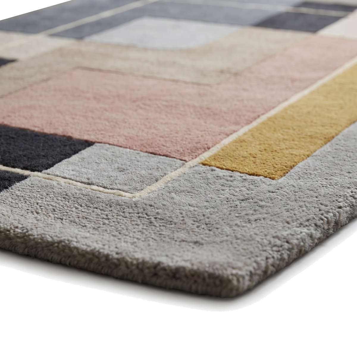 La texture sculptée de la laine tuftée main met en valeur les blocs gris, rose et ocre avec une ligne ivoire