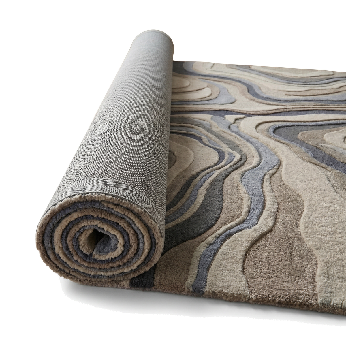 Le dos gris d'un tapis en laine ivoire, sable et bleu ardoise, partiellement déroulé, révèle ses reliefs tondus et bouclés