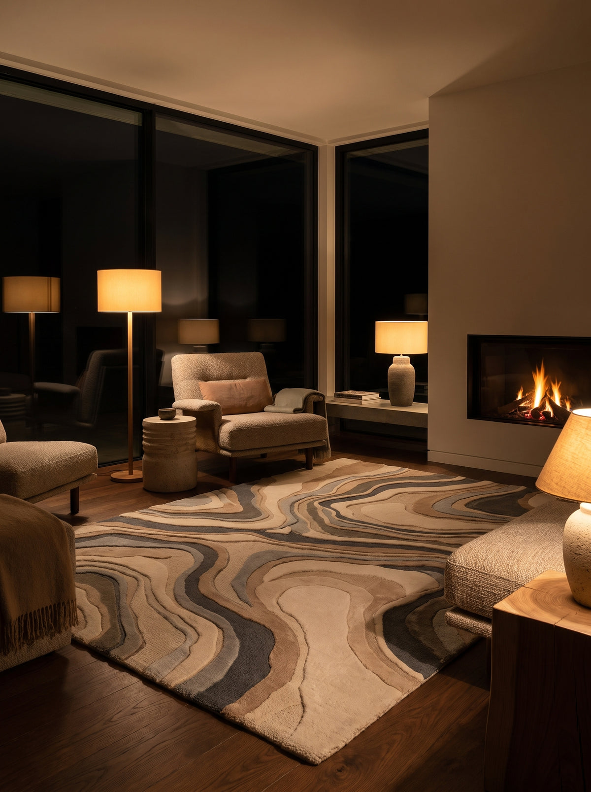 La laine fait main aux motifs ondulants ivoire, sable et bleu ardoise, à reliefs bouclés et tondus, réchauffe le salon