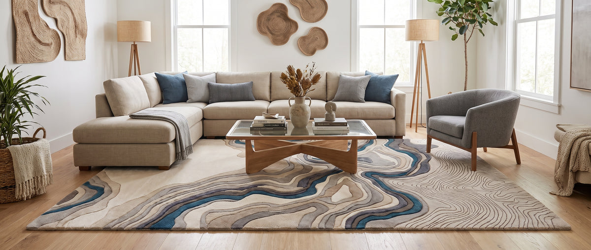 Des reliefs ondulants ivoire, gris et bleu animent ce tapis en laine tuftée main au cœur d'un salon lumineux