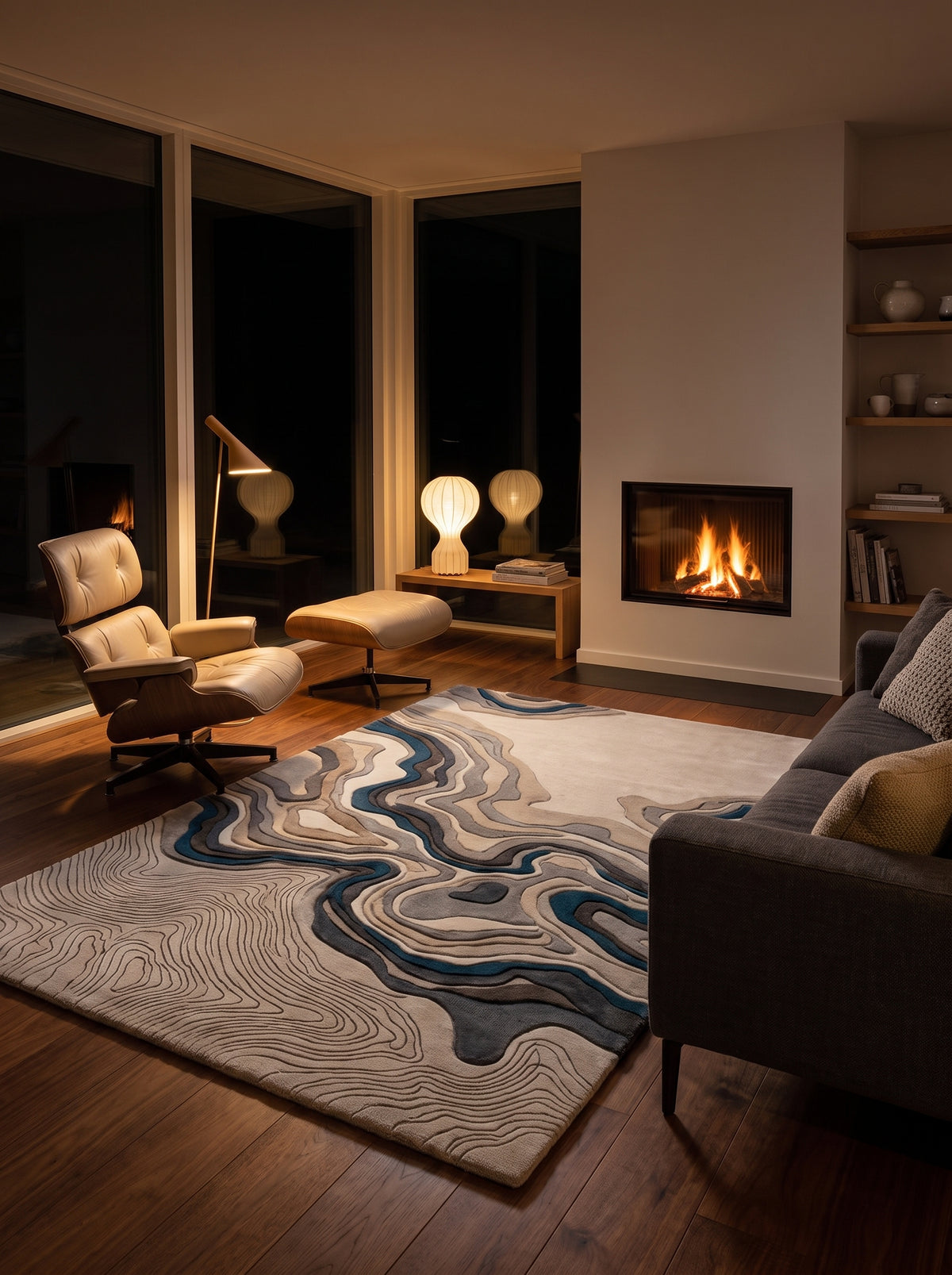 Dans ce salon de nuit, un tapis rectangulaire en laine sculptée révèle des strates ivoire, grises et bleues